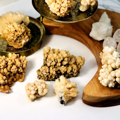 7 Calcite Druzy Formations on a white and wood background