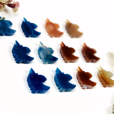 Blue and natural agate unicorn heads being displayed on a white back ground.