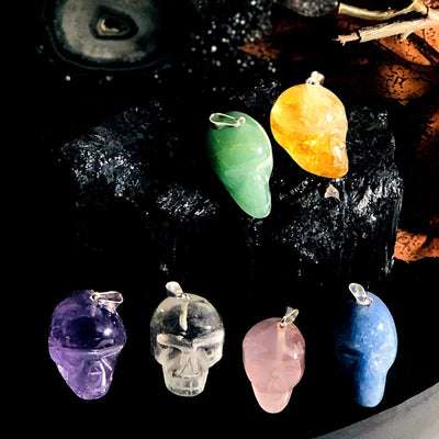 all skull shaped gemstone pendants on display