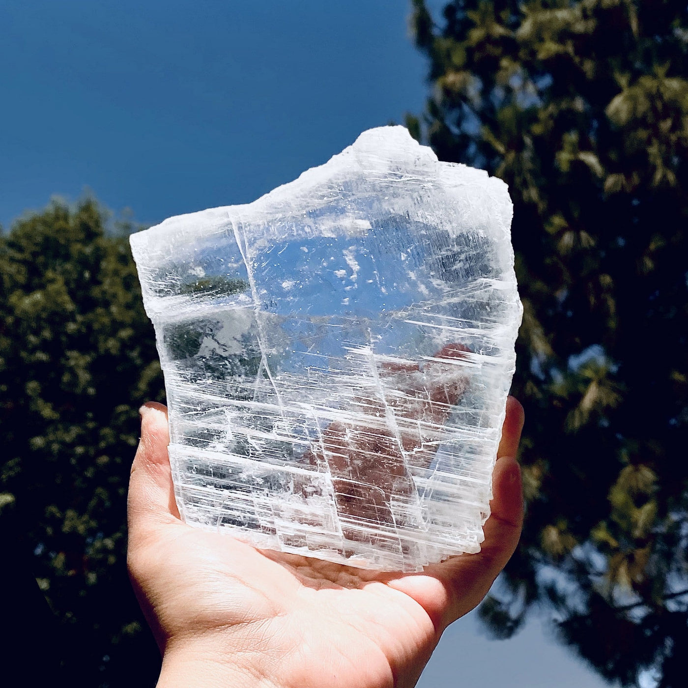 selenite transparent slab in hand for size reference