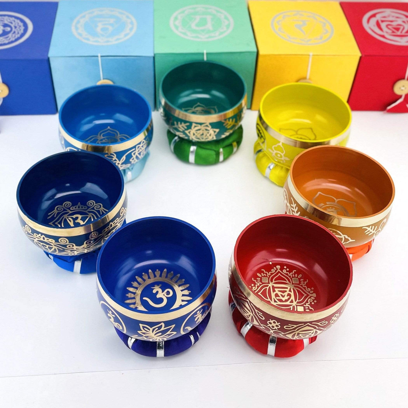 Brass Tibetan Chakra Singing Bowls in a circle showing all colors ontop of their pillows