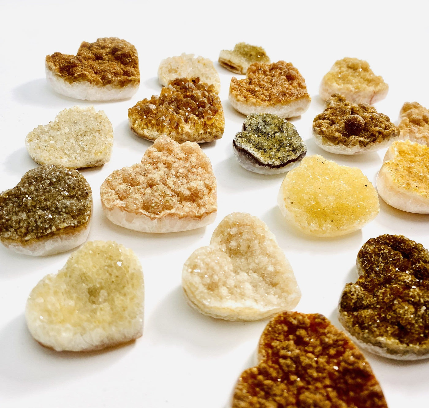 angled shot of Citrine Cluster Druzy Hearts scattered across white background
