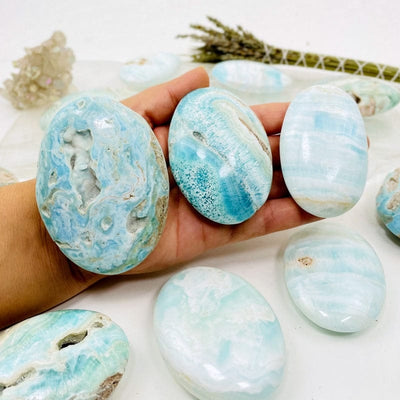 blue aragonite also known as caribbean calcite palm stones in hand