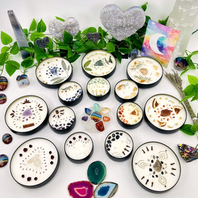 Different types of Chakra Candle Tins with plants and crystals