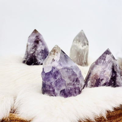 Picture of amethyst ametrine semi polished points displayed on a fury surface.