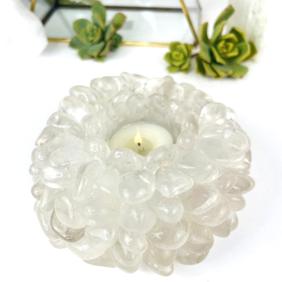 Crystal Quartz Tumbled Stone Candle Holder with a lit votive in it