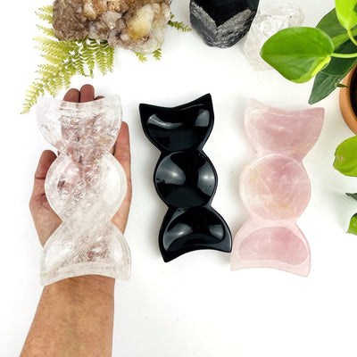 Stone Triple Moon Goddess Bowls, in each of the available stone:black obsidian, rose quartz and crystal quartz, with one in a hand for size reference