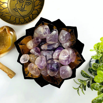 amethyst tumbled stones with decorations in the background