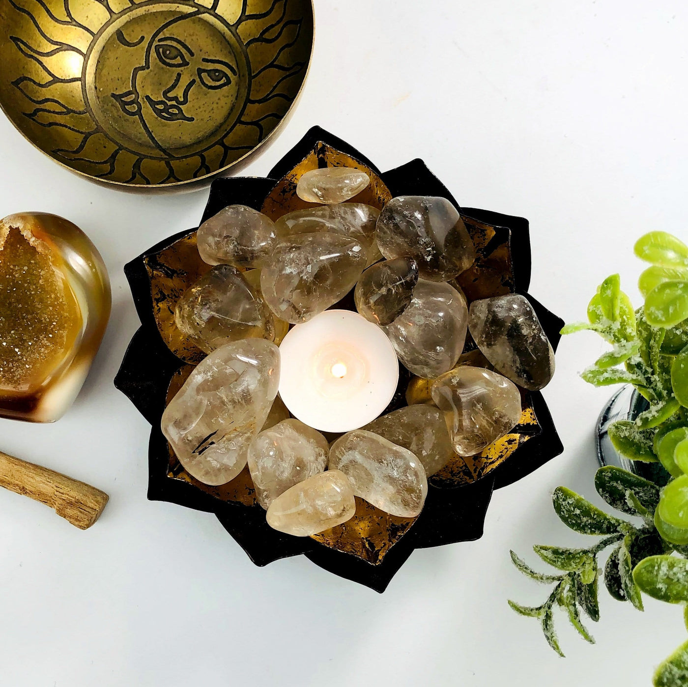 Smokey Quartz Tumbled Gemstones in a gold dish with candle