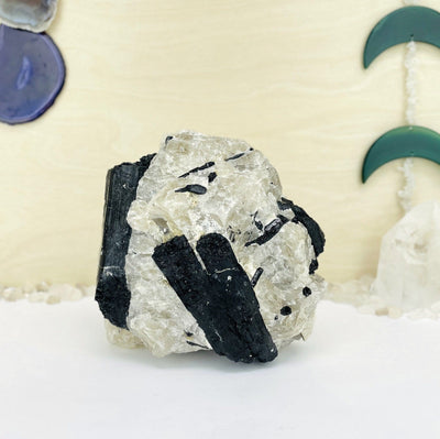 Black Tourmaline on Matrix with decorations in the background