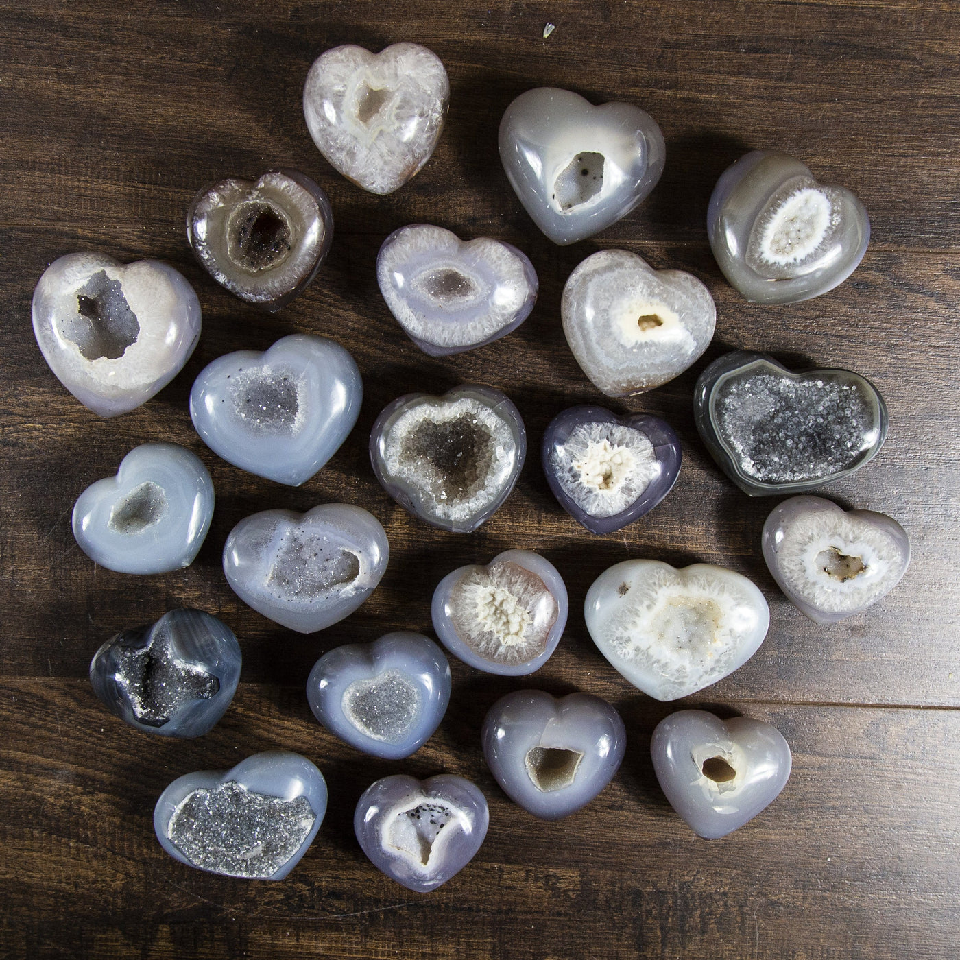 Many agate druzy hearts displayed front facing on a dark background.
