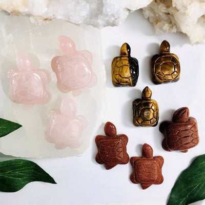 3 rose quartz 3 tigers eye and 3 gold stone turtles on a table