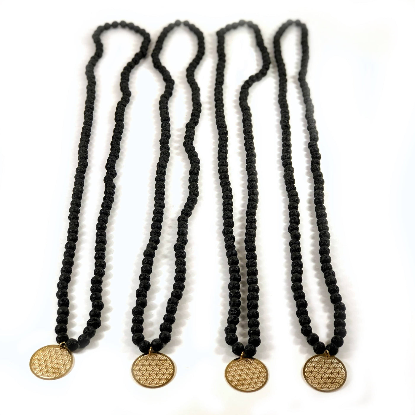 4 Diffuser Necklace Lava Bead with Flower of Life Charm in Gold on White Background.