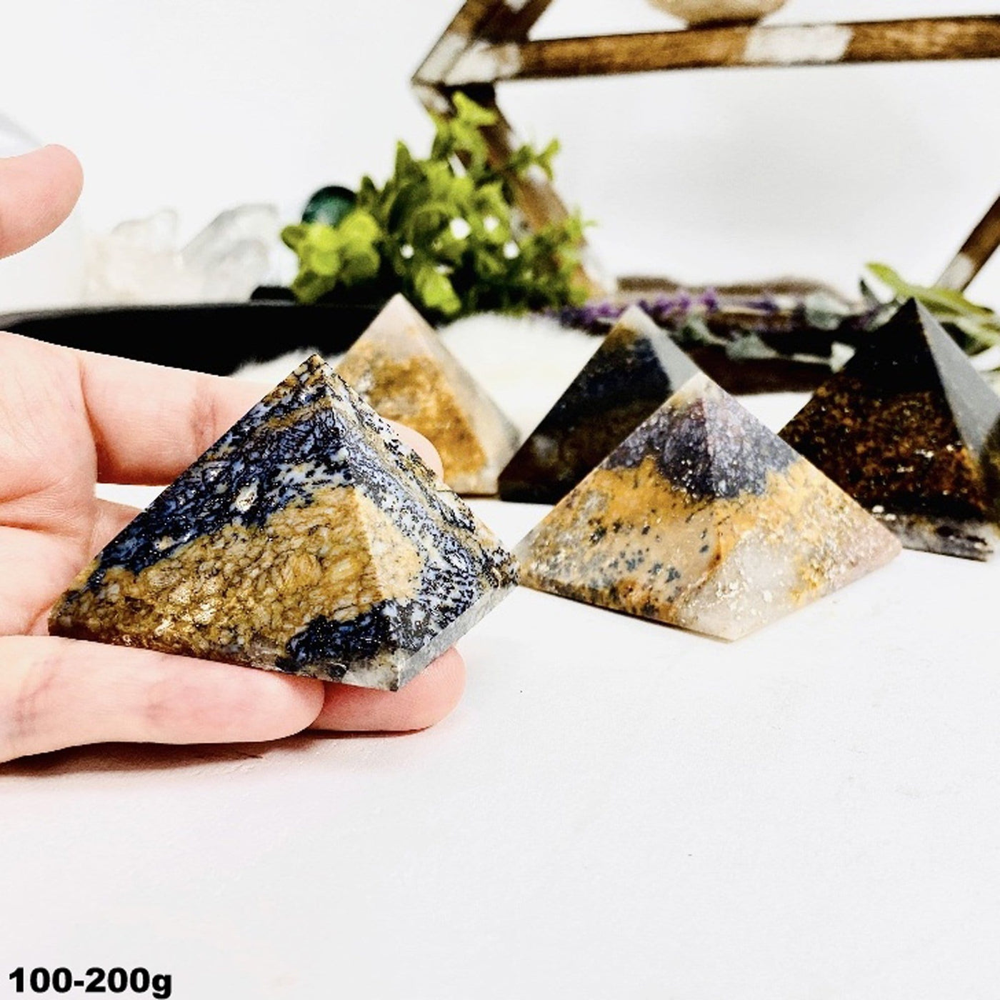 100-200g Lions Eye Jasper Pyramid in hand for size reference