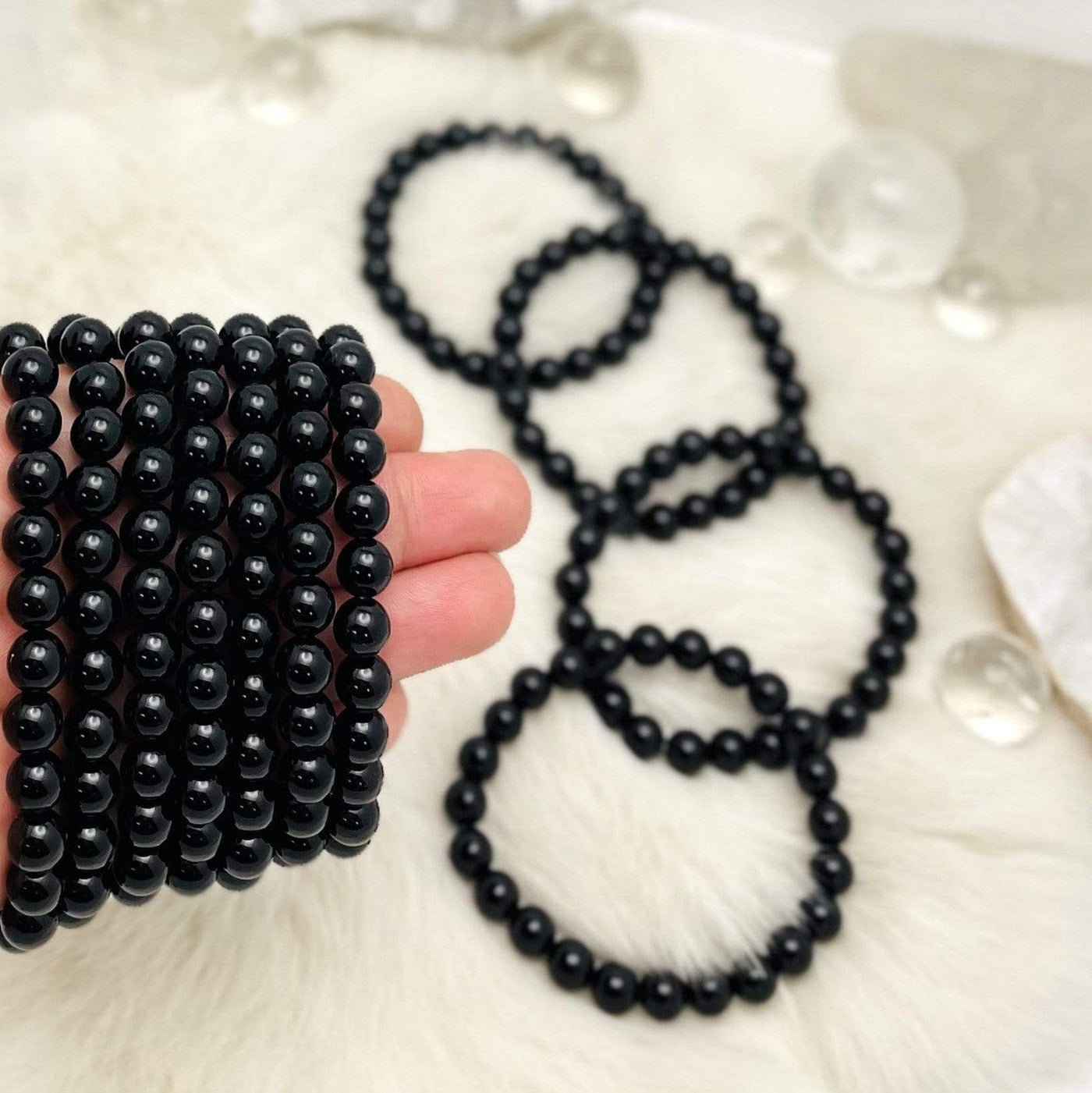 7 Black Agate Round bracelets in a row on top of hand