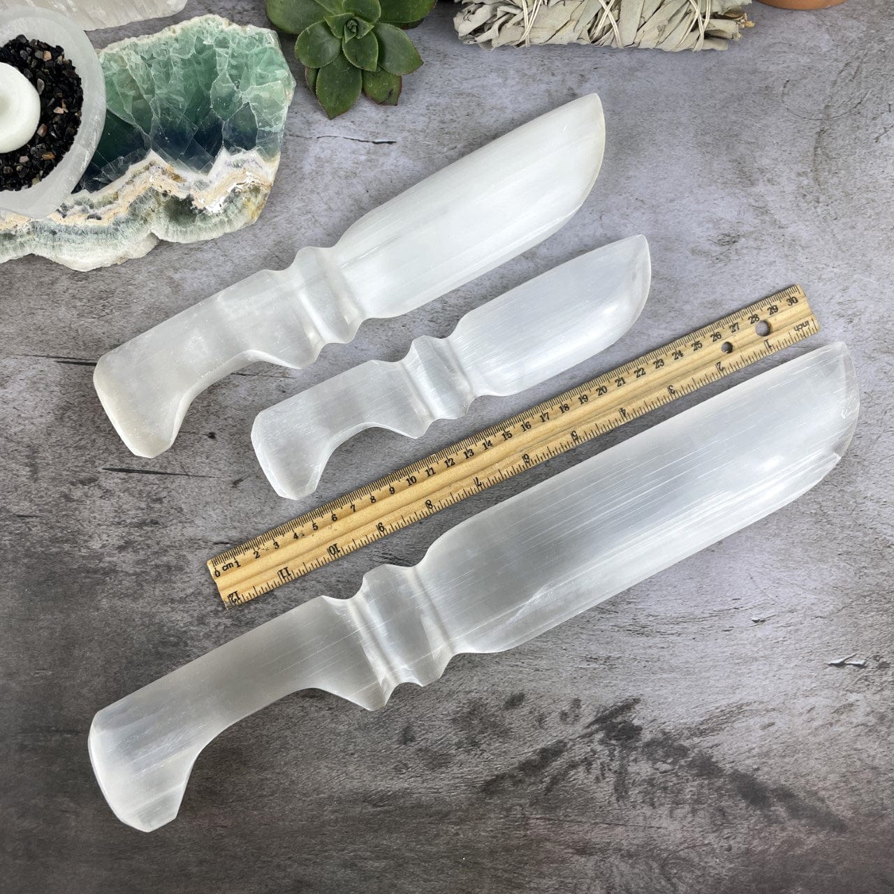3 sizes of Selenite Knives with Hand Cut and Polished Handles next to a ruler for sizing