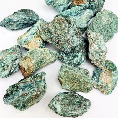 a bunch of Fuchsite Natural Stones on a table
