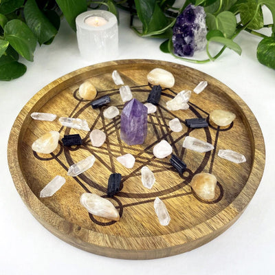 small Metatron Wood Tray in Mango Wood with crystals displayed inside and assorted crystals for decoration next to it on a white background