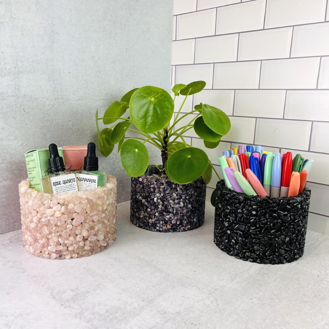 3 Tumbled Stone Pot/Holders #4, shown here holding a plant, oils bottles, pens