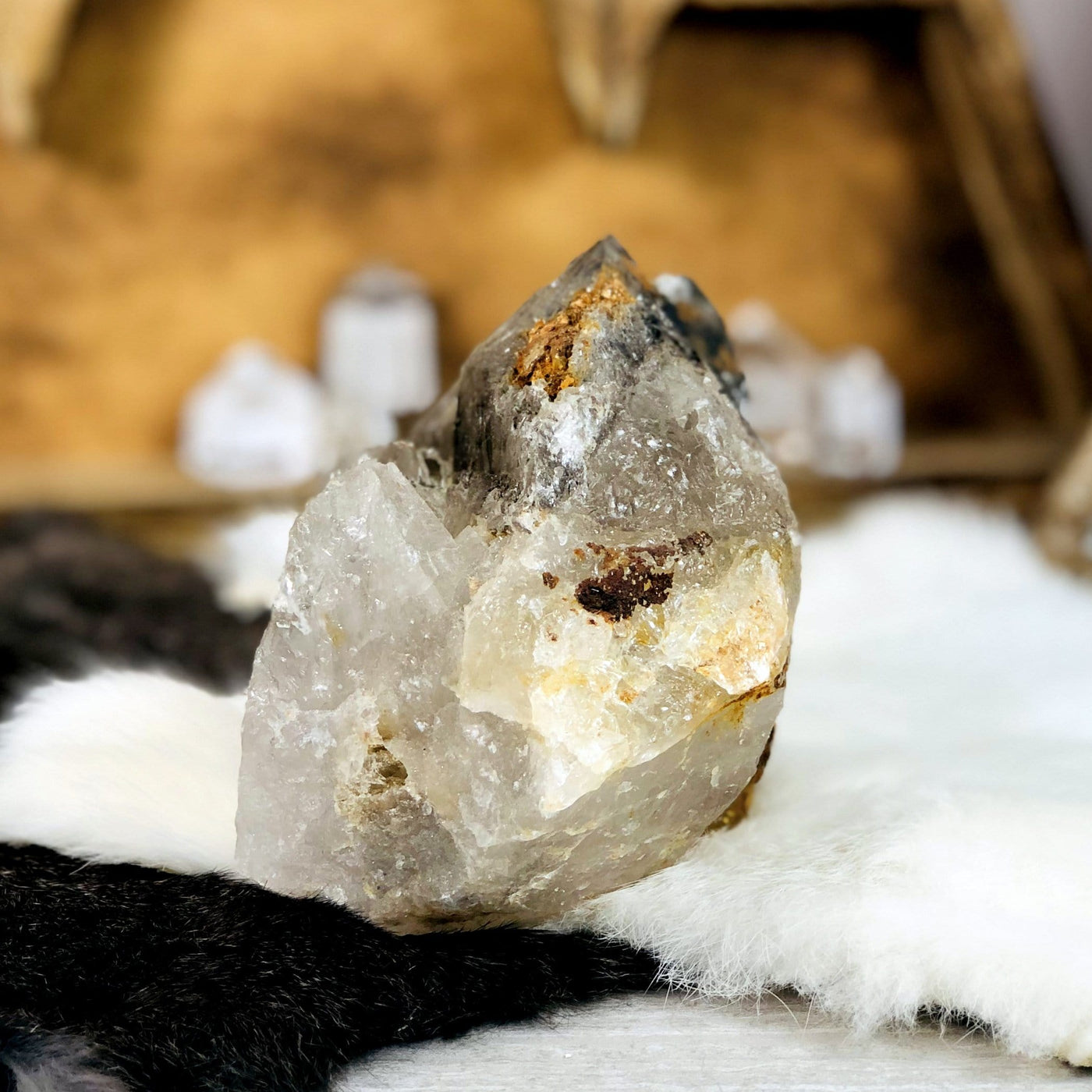 Smokey Quartz raw Point with decorations in the background