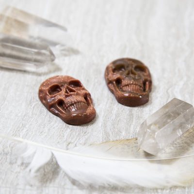 angled view of two skull shaped goldstone pieces for thickness