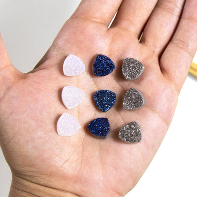 triangle shaped druzy cabochons on hand for size reference