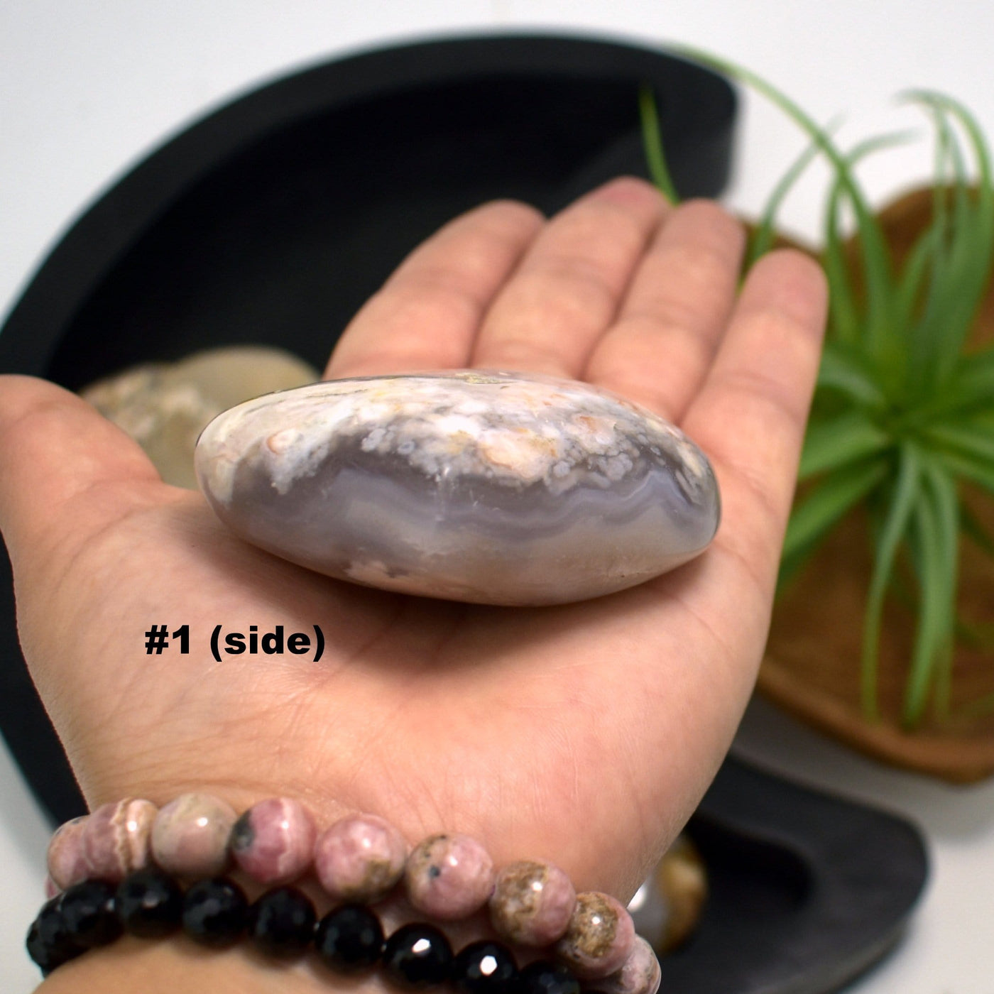 hand holding up Flower Agate Polished Stone Heart showing side view