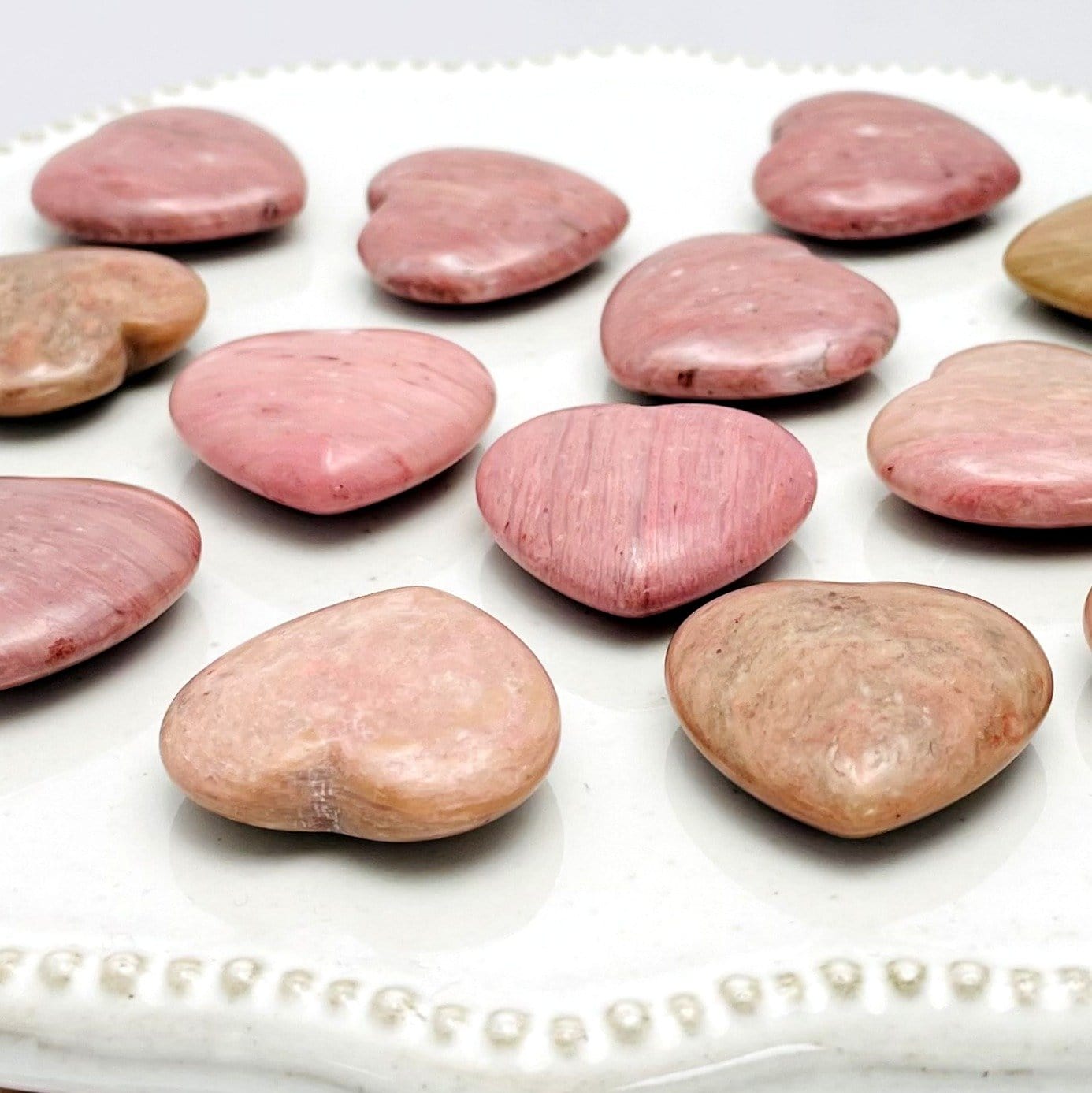 Side view of Rhodonite Heart Shaped Stones on white background