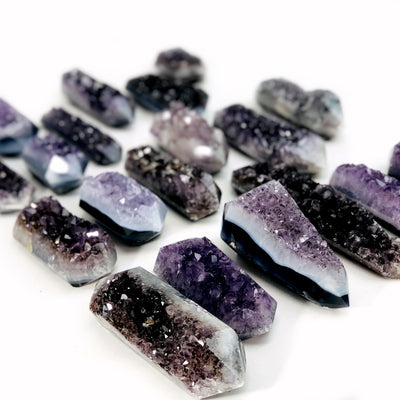 angled shot of amethyst druzy polished double points on white background