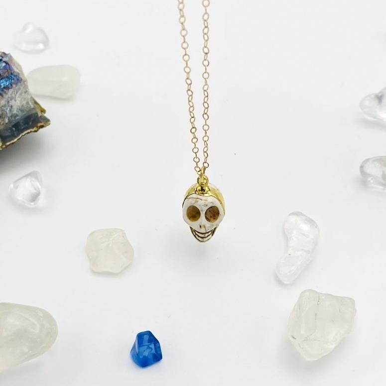one white howlite skull pendant necklace hanging over white background