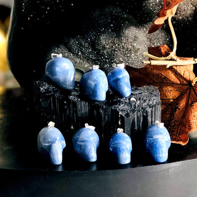 many blue quartz skull shaped pendants on display for possible variations
