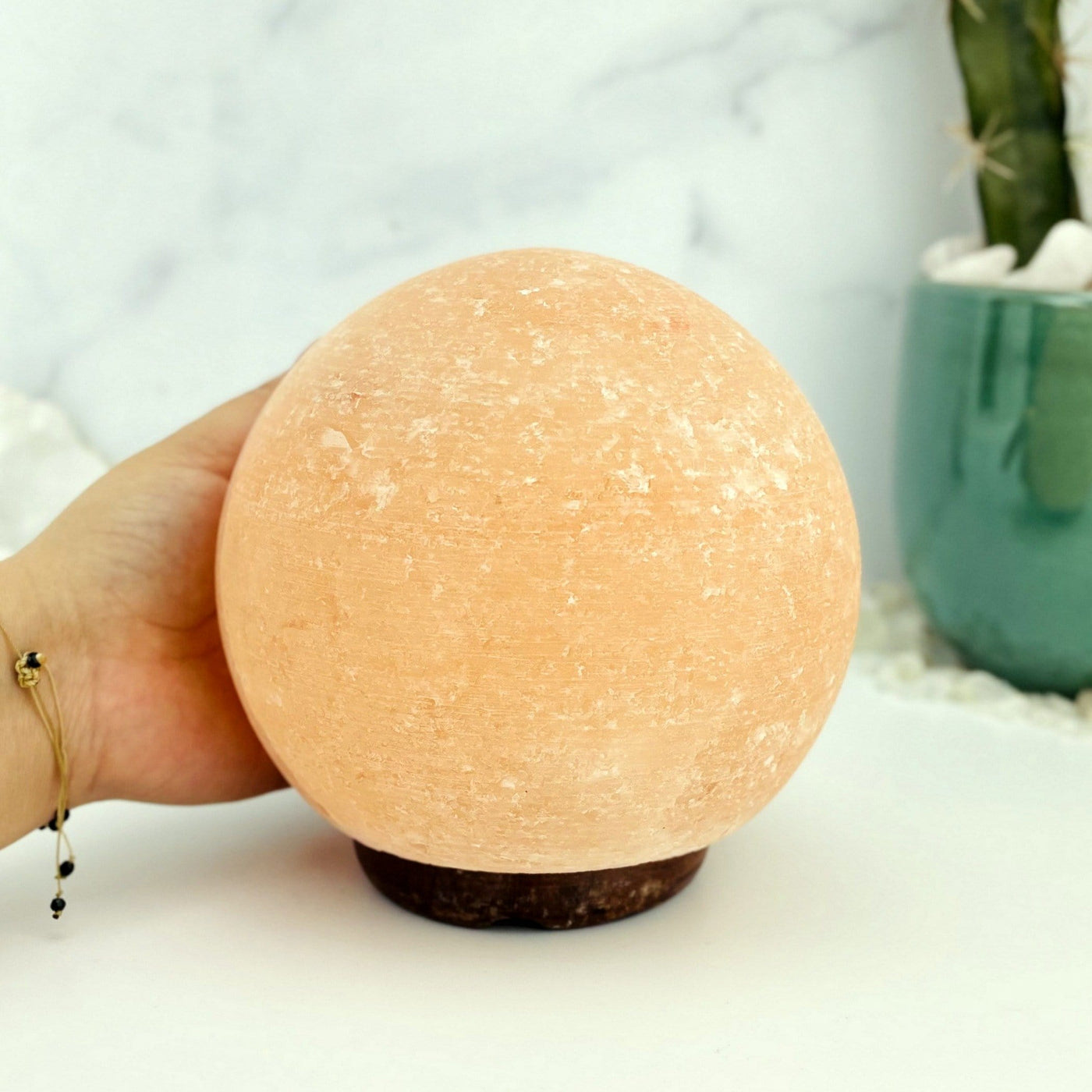 Himalayan Salt Lamp sphere with a hand by it