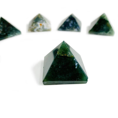 Moss agate assorted pyramids on a white background.