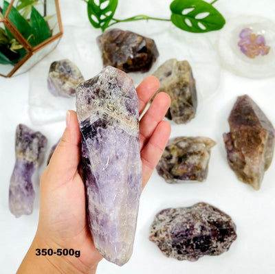 350g-500g seven mineral tumbled stone in hand for size reference with others in background display