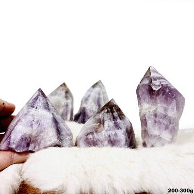Picture of three amethyst ametrine semi polished points displayed on a fury surface.