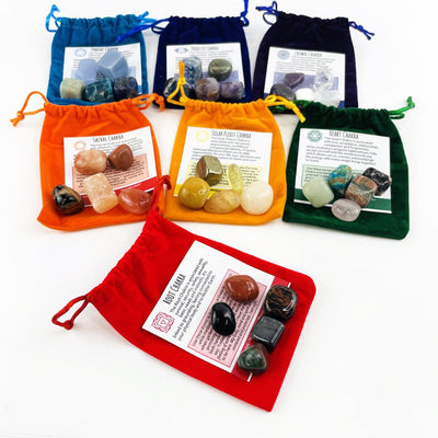 All the Sets of the 7 Chakra Colorful Plush Pouches with informations card and stones on top of them