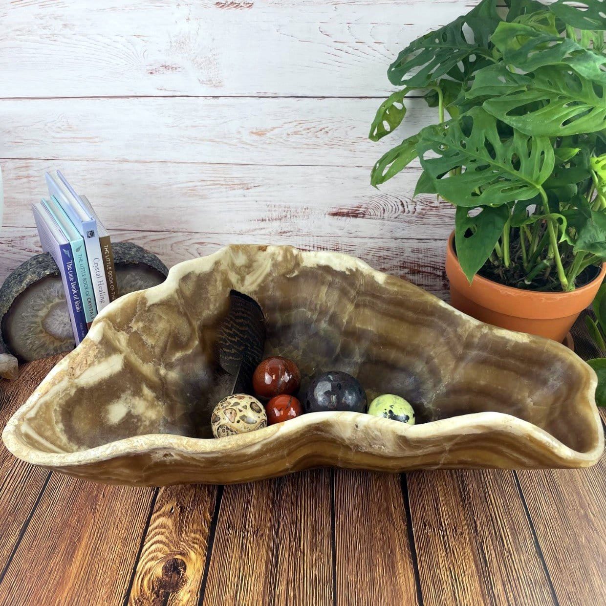 Mexican Onyx Bowl with crystals in it and decorations in the background