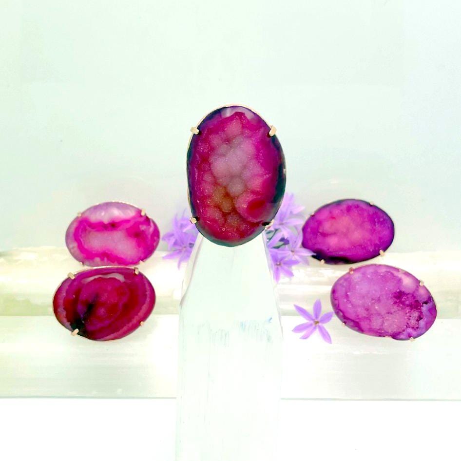 5 pink agate rings on a table