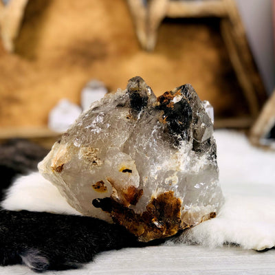 Smokey Quartz raw Point with decorations in the background