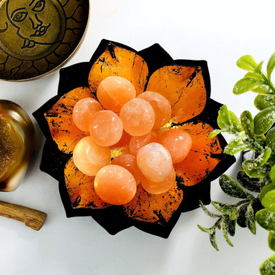 Orange selenite spheres in a lotus dish.