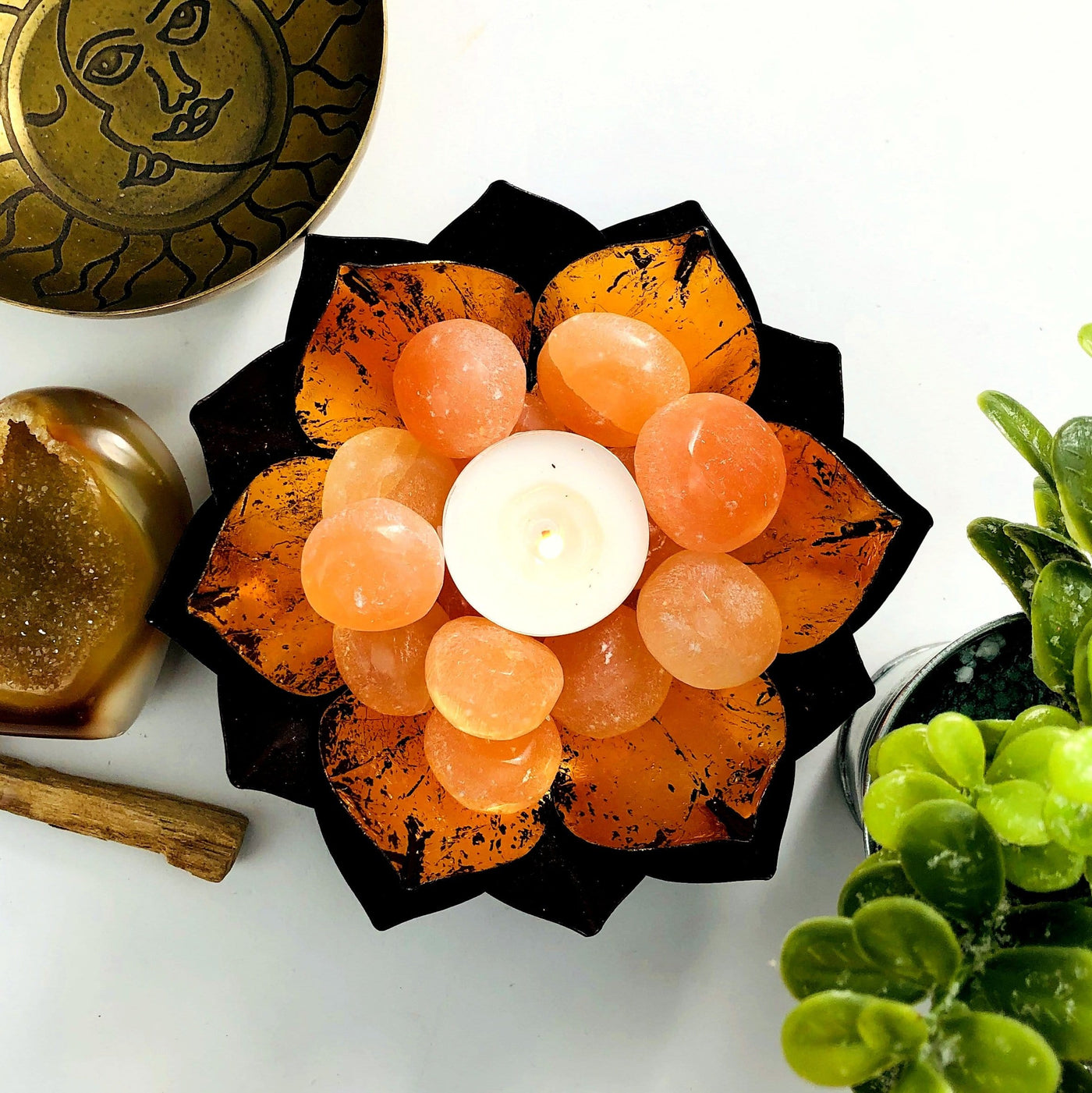 Orange selenite spheres in a lotus candle holder.