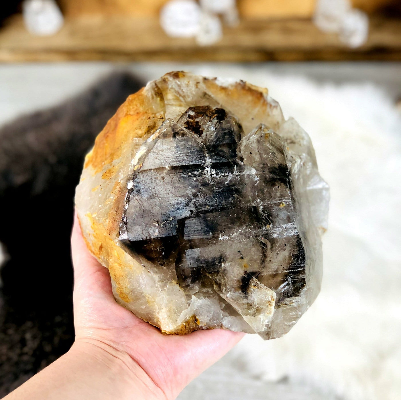smokey quartz raw point in hand for size reference