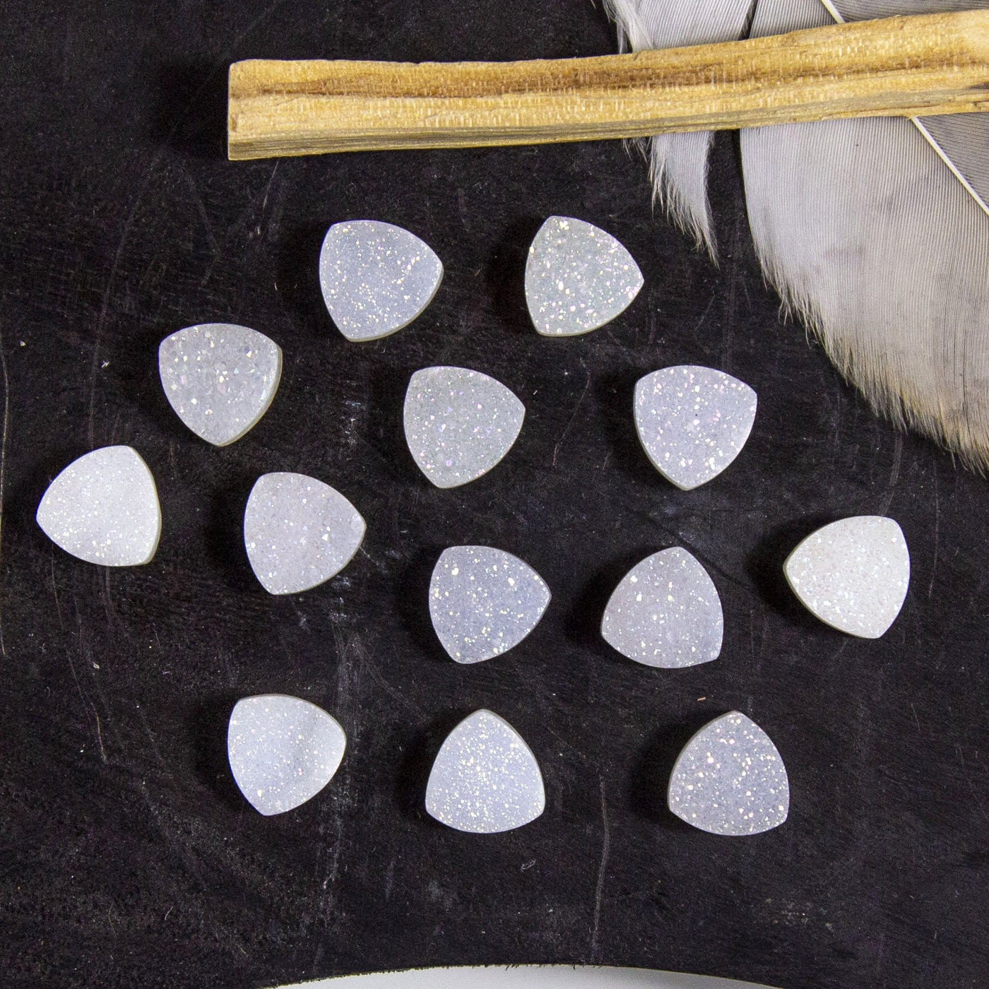 multiple white triangle druzy cabochons displayed on black background
