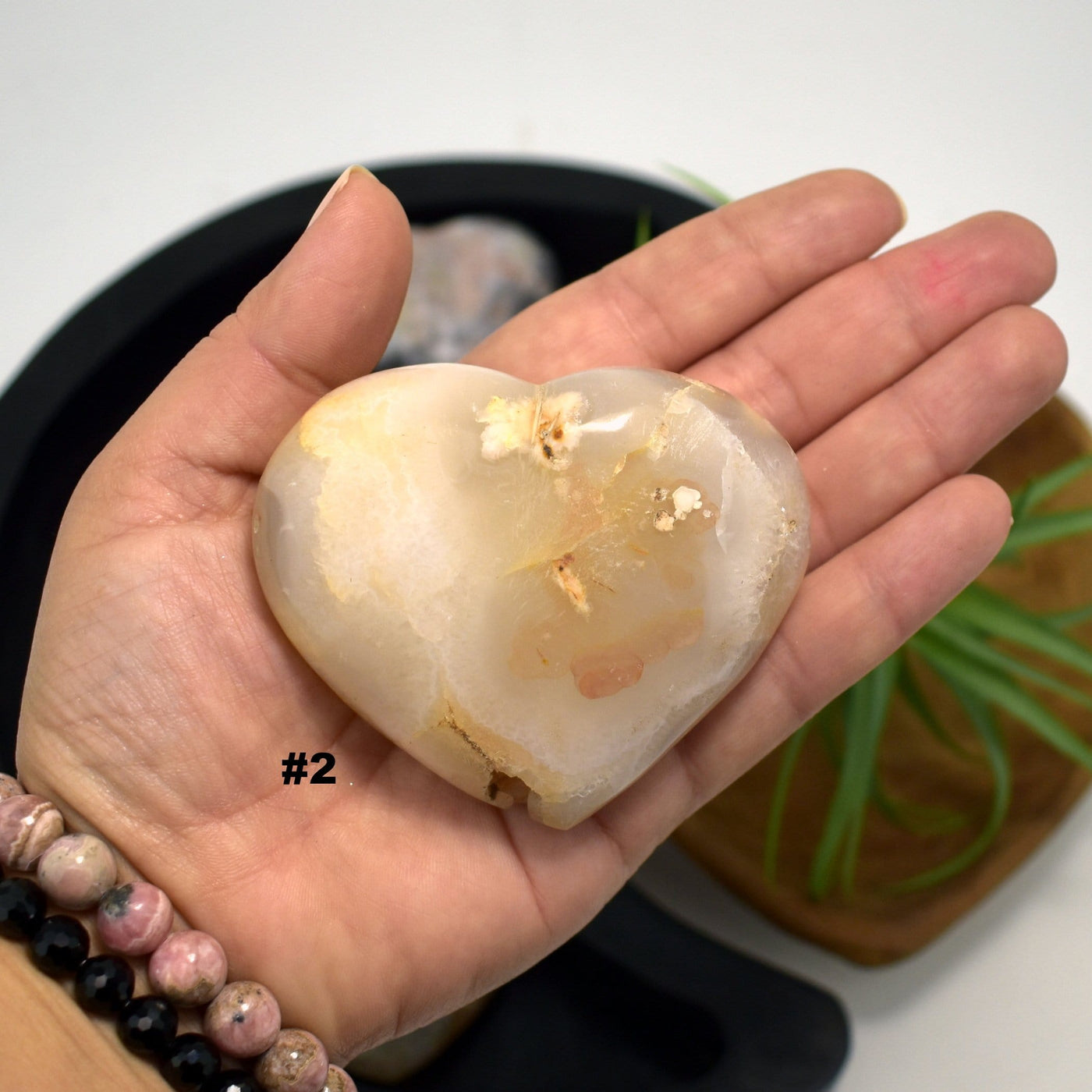 hand holding up Flower Agate Polished Stone Heart