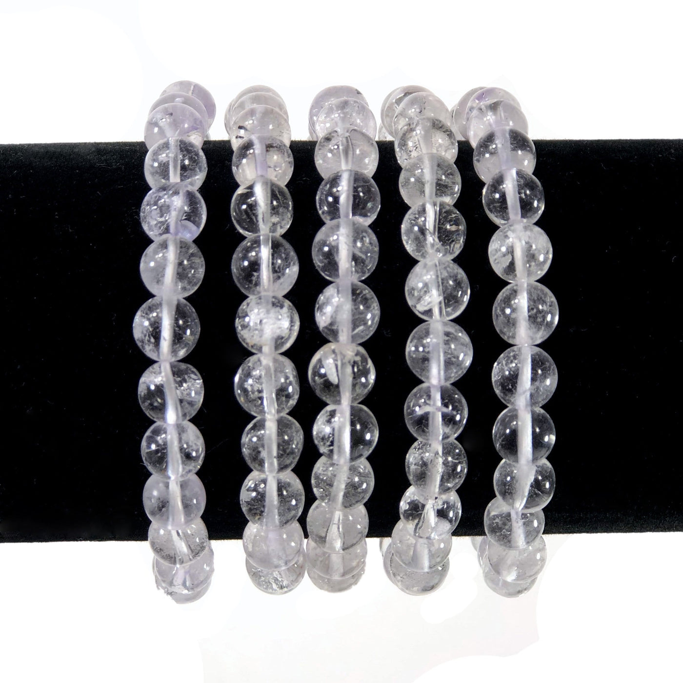 crystal quartz healing stone bracelets on a display stand with white background
