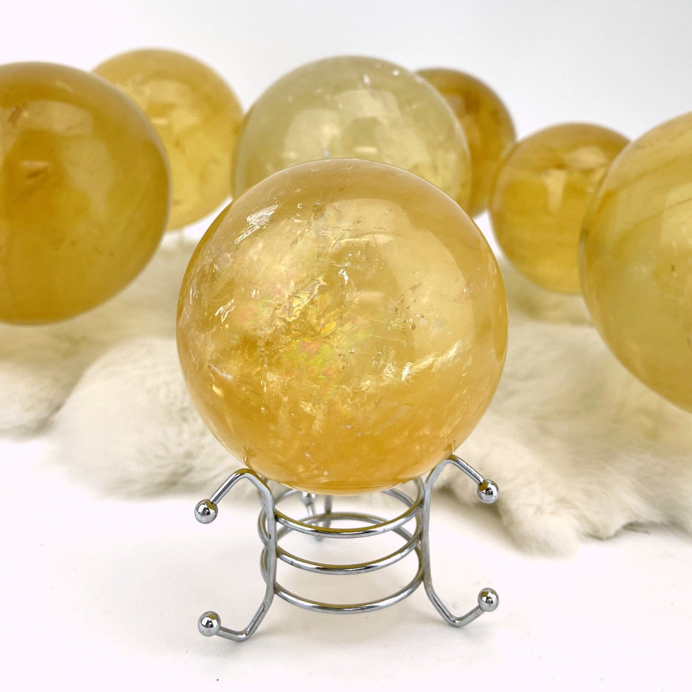 up close shot of Honey Calcite Polished Sphere with others in the background