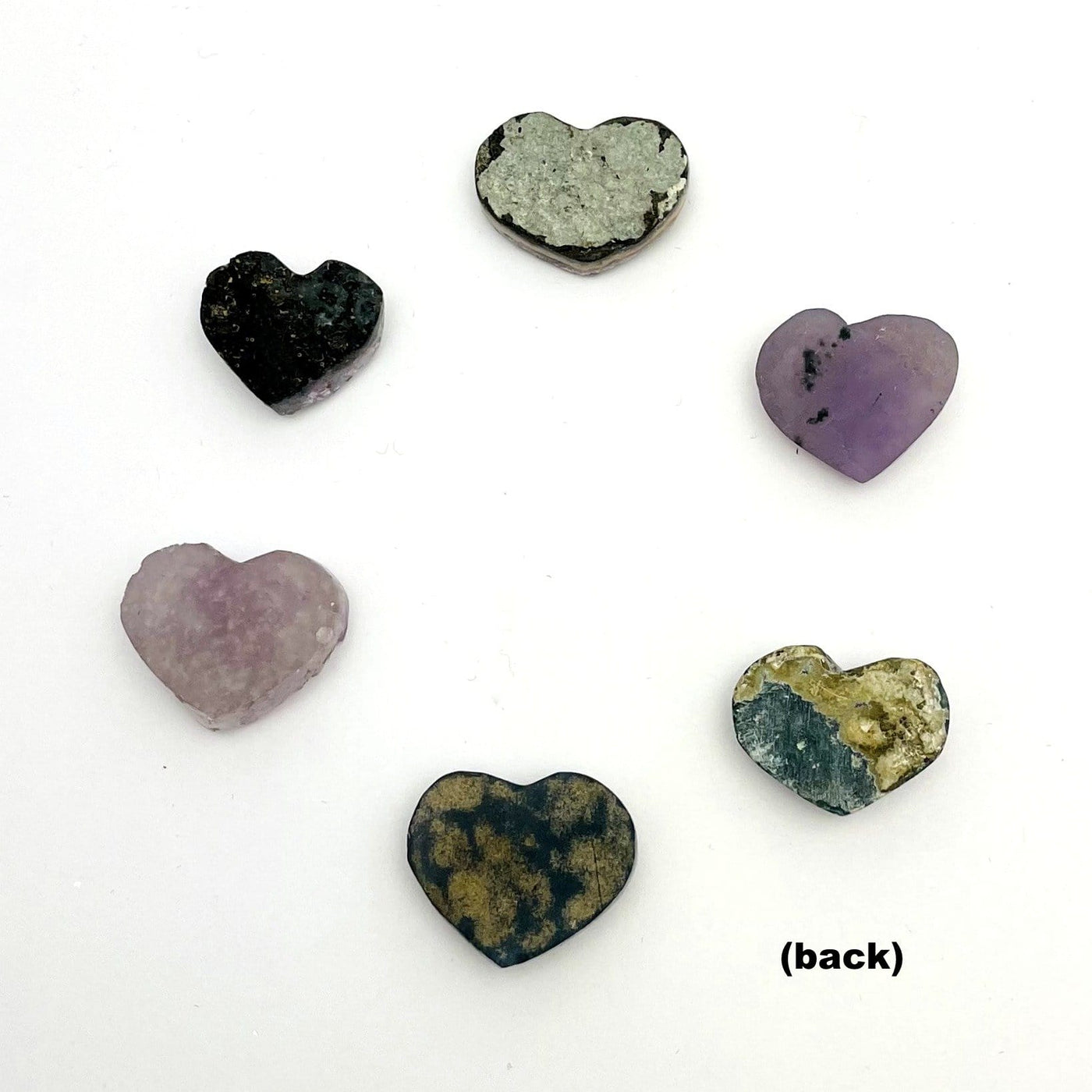 Backside of amethyst hearts showing they are various shades of smoother rock.