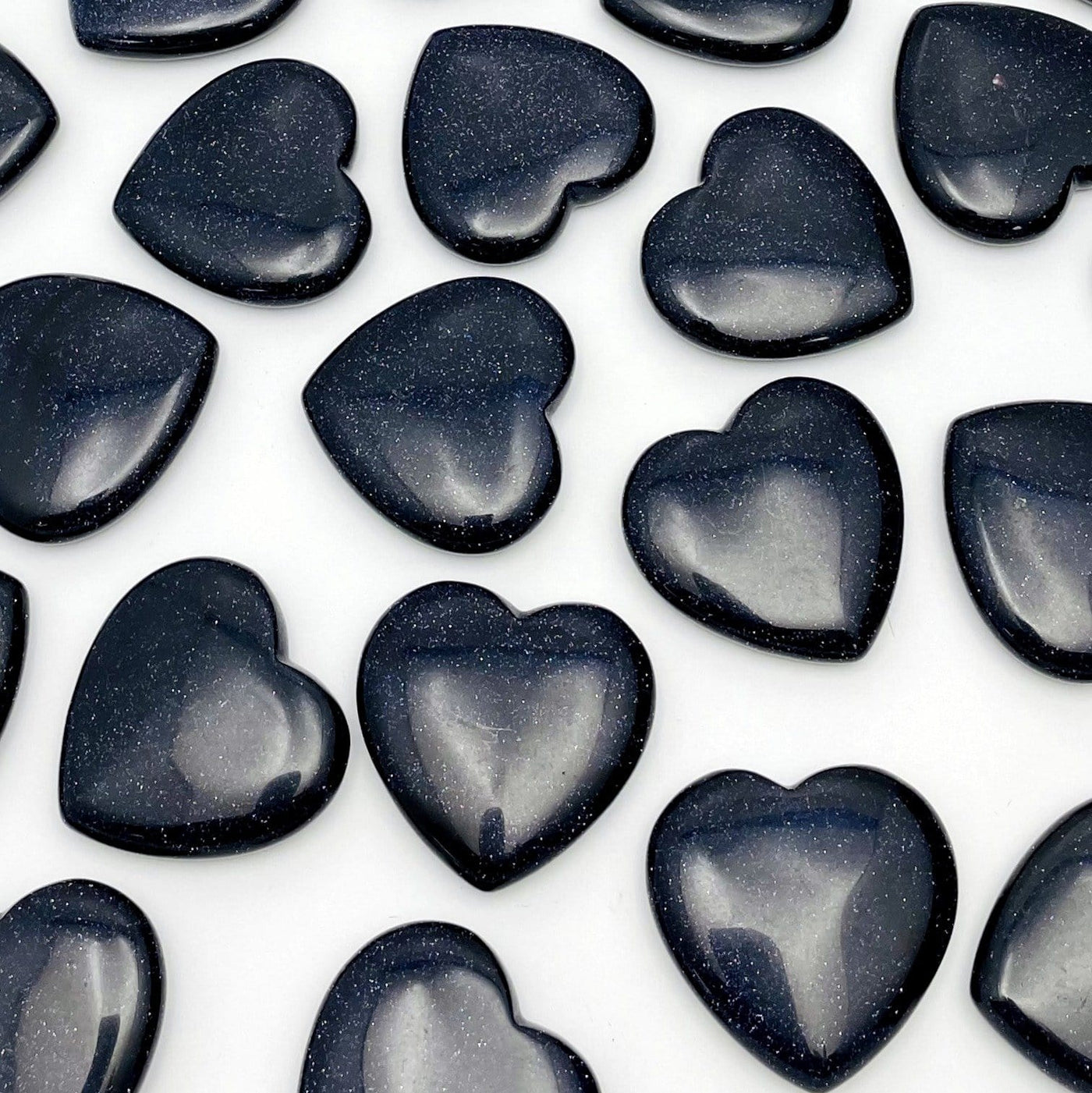 Multiple Dark Blue Goldstone Hearts on White Background.