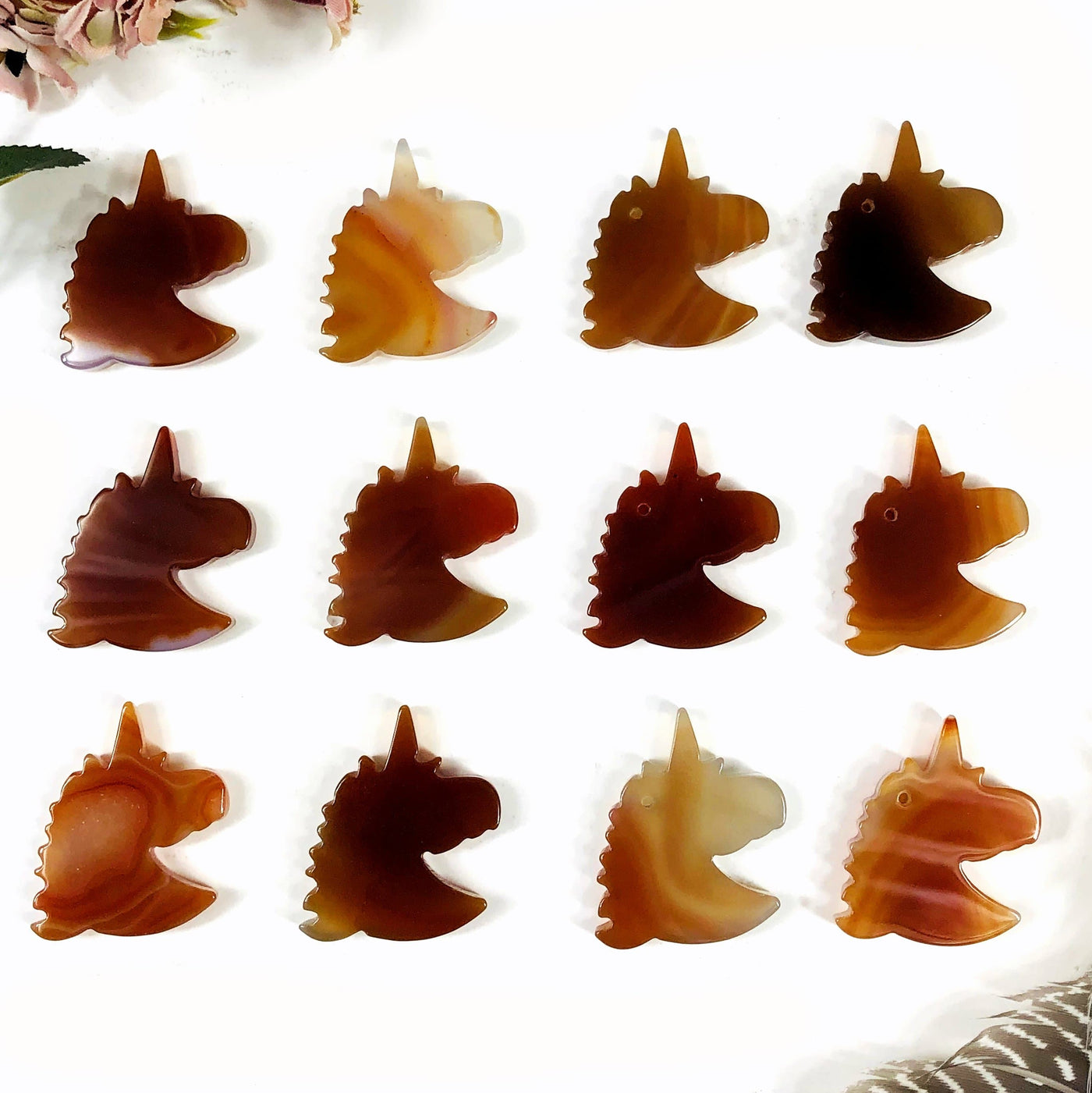 Natural agate unicorn heads being displayed on a white background.
