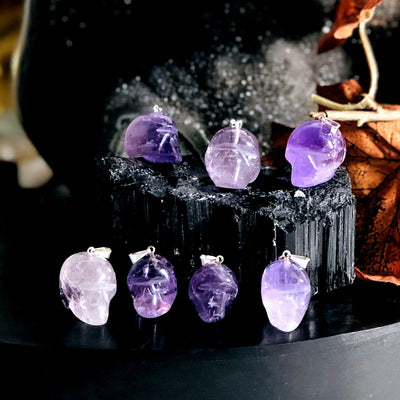 many amethyst skull shaped pendants on display for possible variations